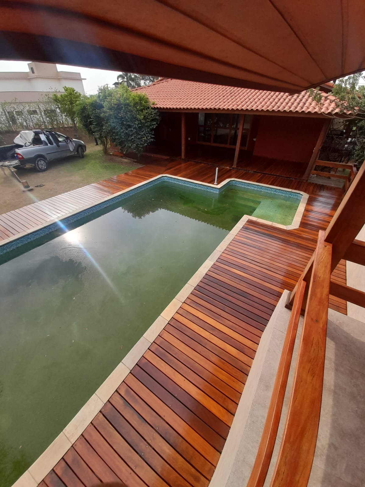 Deck de madeira em volta da piscina após raspagem e tratamento em Campinas