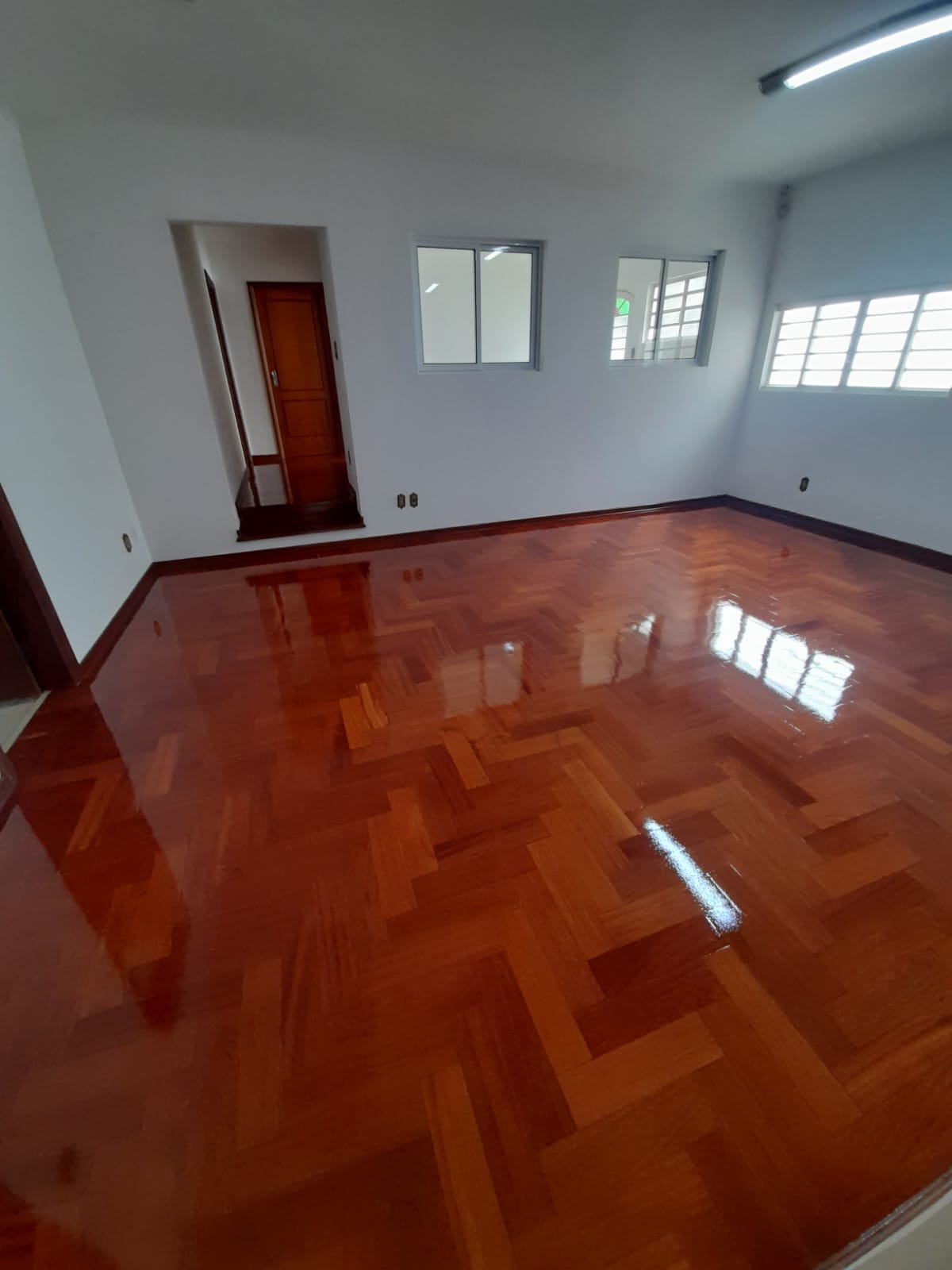 Sala com taco em espinha de peixe com acabamento brilhante em Campinas