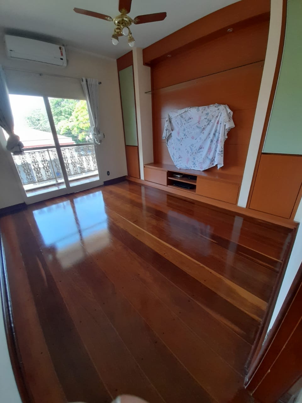 Sala com assoalho de madeira raspado e envernizado em Campinas