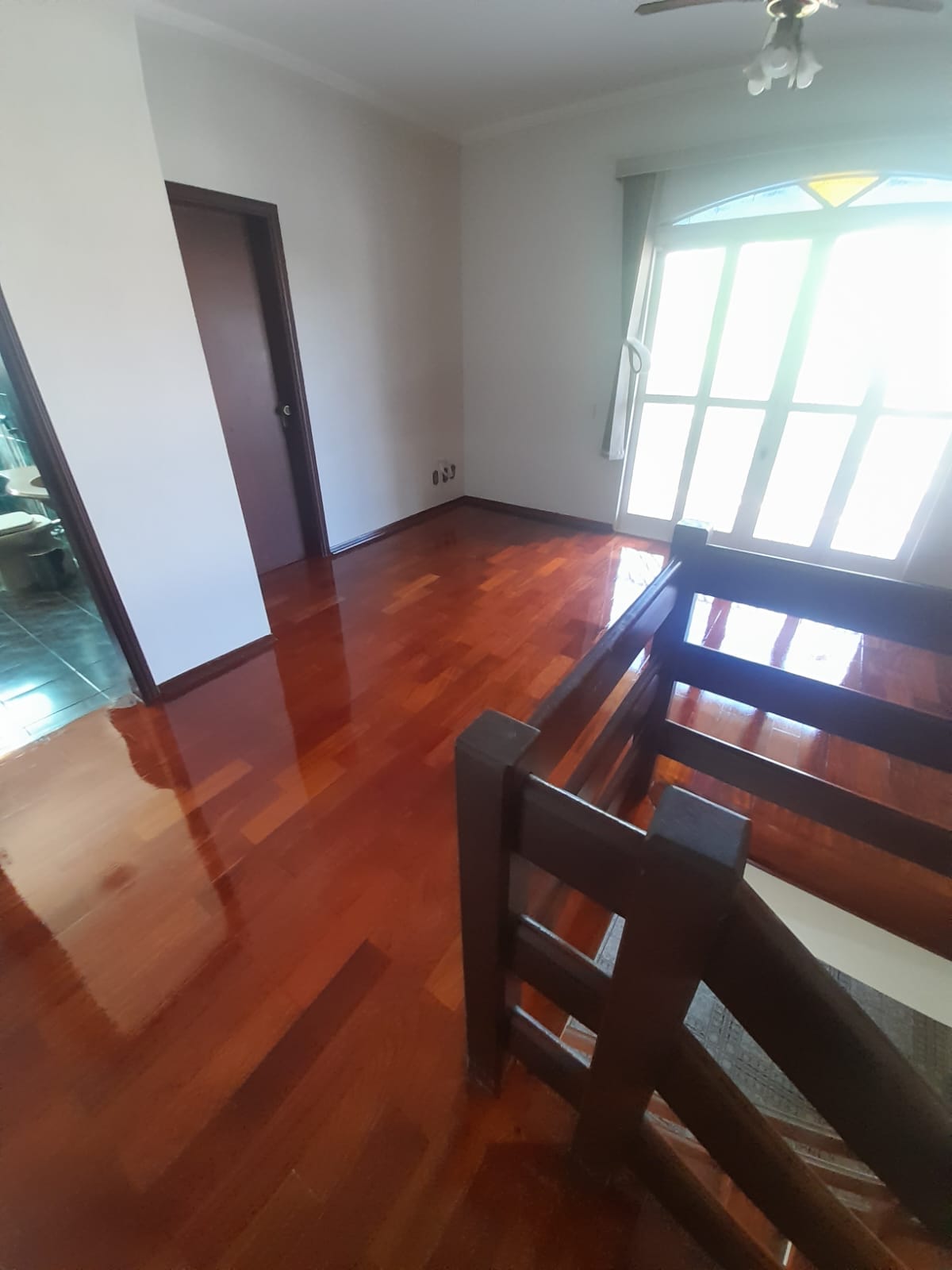 Mezanino com piso de taco envernizado e guarda-corpo de madeira em Campinas