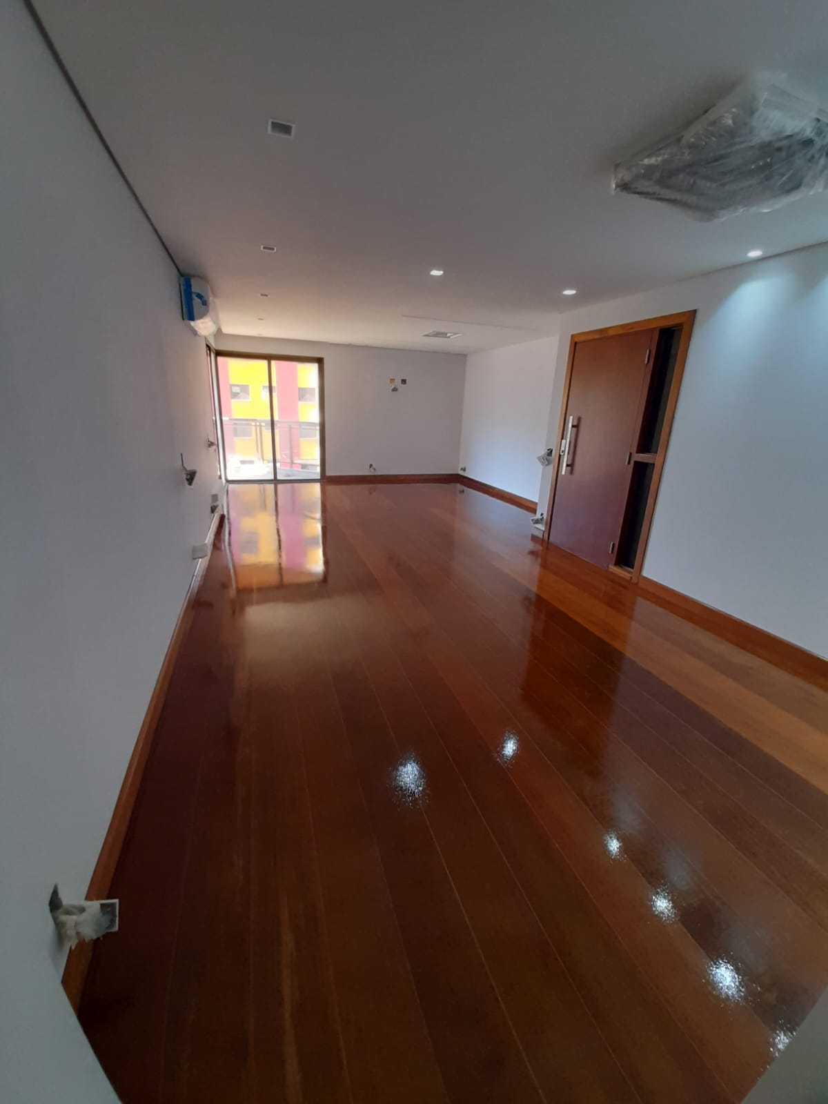 Corredor com assoalho de madeira restaurado em Campinas