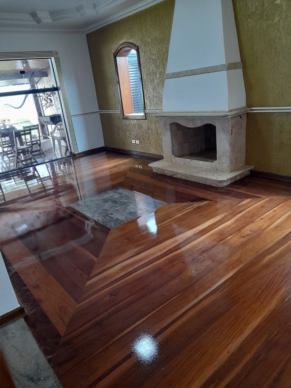 Sala com lareira e piso de madeira com paginação decorativa em Campinas