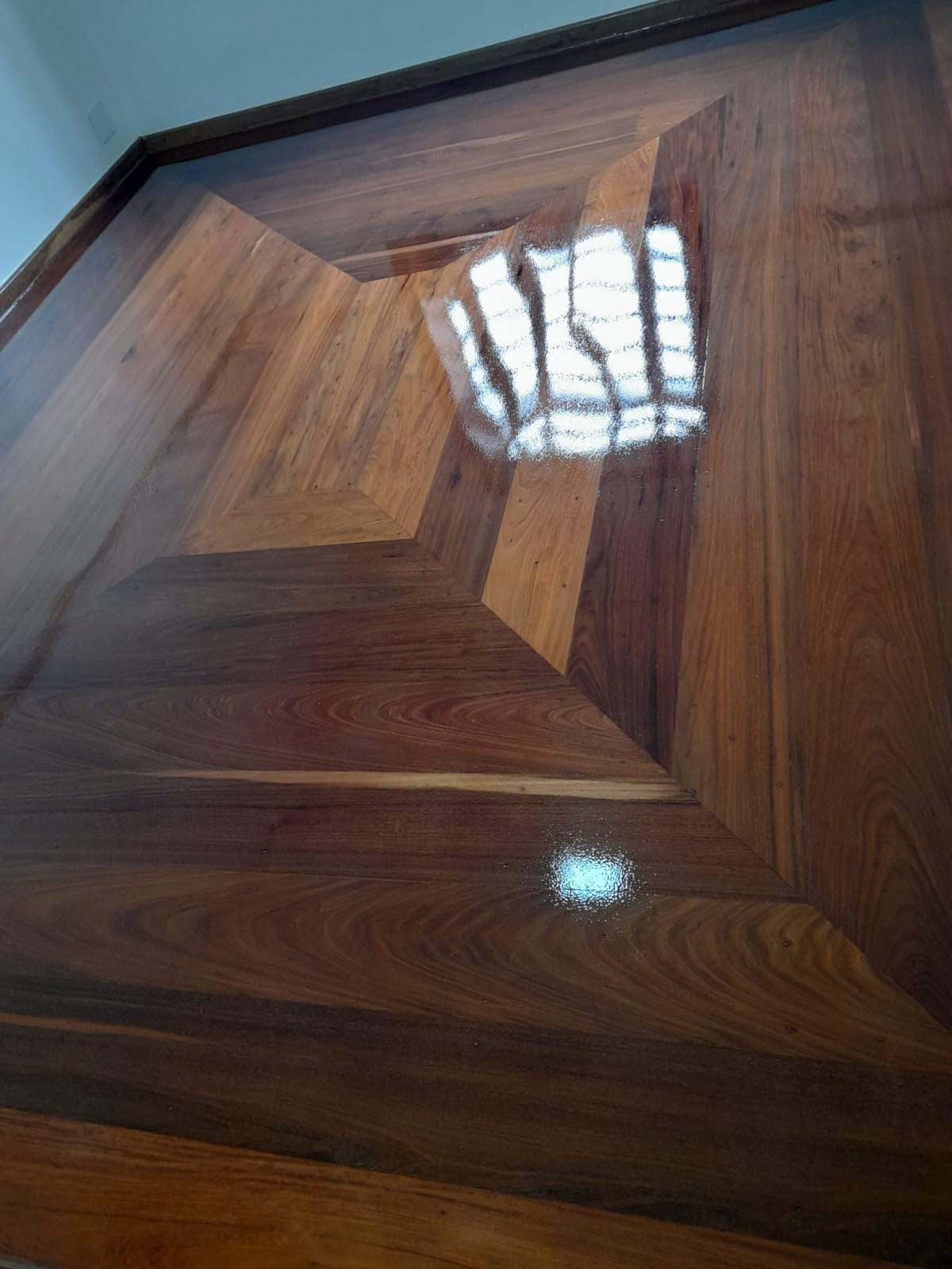 Detalhe de piso de madeira com desenho em losango envernizado em Campinas