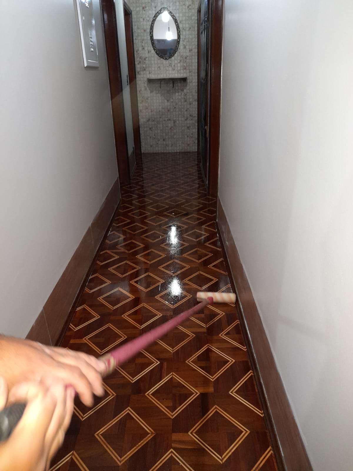 Aplicação de verniz em corredor com piso de madeira marchetado em Campinas