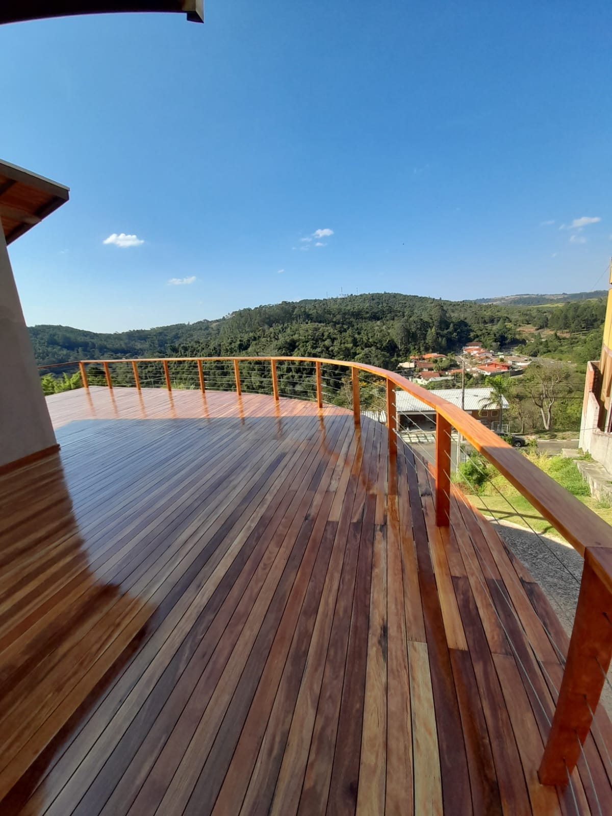 Deck de madeira em varanda com vista para a serra, após restauração em Campinas